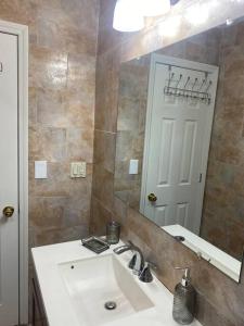 a bathroom with a sink and a large mirror at Cozy 2-bedrooms bungalow in Canarsie Brooklyn in Brooklyn