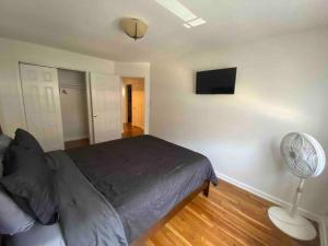 a bedroom with a bed with a fan and a lamp at Cozy 2-bedrooms bungalow in Canarsie Brooklyn in Brooklyn