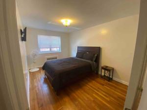 a bedroom with a bed and a fan in it at Cozy 2-bedrooms bungalow in Canarsie Brooklyn in Brooklyn