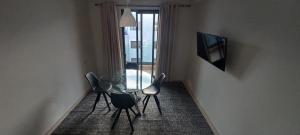 room in Residence Lilya fermée et sécurisée في الدار البيضاء: غرفة طعام مع طاولة زجاجية وكرسيين