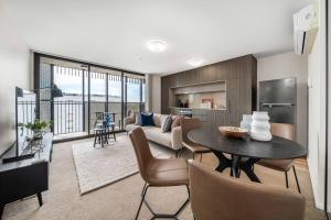 ein Wohnzimmer mit einem Tisch und einem Sofa in der Unterkunft Luxury Heights on Flinders in Adelaide