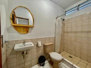 a bathroom with a toilet and a sink and a mirror at Hostal Namborus in Rivas