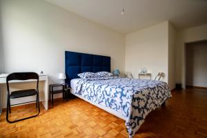 um quarto com uma cama com uma cabeceira azul e uma secretária em hyper centre carouge QDC em Genebra