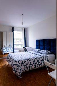 sypialnia z dużym łóżkiem z niebieskim zagłówkiem w obiekcie hyper centre carouge QDC w Genewie