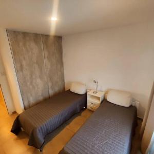 una camera con 2 letti e un comodino con un comodino. di El Descanso a Olavarría