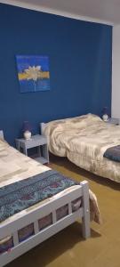 2 camas en una habitación con paredes azules en HOTEL PARAISO en La Cumbre
