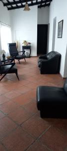 um quarto com sofás e cadeiras num piso de azulejo em HOTEL PARAISO em La Cumbre