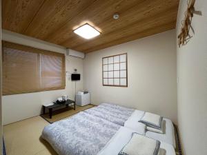 um quarto com uma cama grande e um tecto de madeira em Karin doo Hotel em Narita