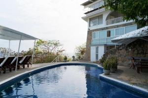 a swimming pool in front of a building at Casas del Acantilado - Acapulco in Acapulco