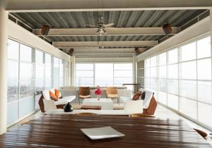 Una sala de estar con muebles blancos y grandes ventanales. en Casas del Acantilado - Acapulco, en Acapulco