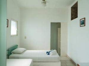 a white room with two beds and a window at Casas del Acantilado - Acapulco in Acapulco