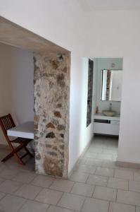 um quarto com uma parede de pedra, uma mesa e um lavatório em Casas del Acantilado - Acapulco em Acapulco
