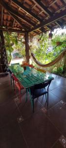 une table verte avec deux chaises et un hamac dans l'établissement Recanto da Poesia, à Campo Grande