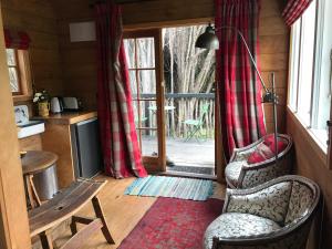 uma sala de estar com 2 cadeiras e uma porta de vidro deslizante em Kanuka Retreat em Akaroa