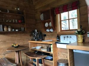 cocina con paredes de madera y encimera con taburetes en Kanuka Retreat, en Akaroa