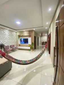 a lobby with a hammock in the middle of a room at Casa com Piscina Privativa na Lagoa do Paraíso - John House Paradise in Jijoca de Jericoacoara