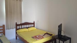 sypialnia z łóżkiem i telewizorem z obrazem w obiekcie Pousada Renascer w mieście Cuiabá