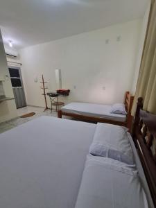 a room with two beds and a table in it at Pousada Renascer in Cuiabá