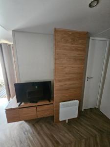 een woonkamer met een tv en een houten deur bij marie & cyrille in Lattes