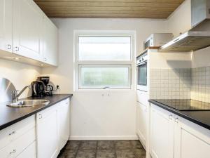 a kitchen with white cabinets and a window at 10 person holiday home in V ggerl se in Marielyst