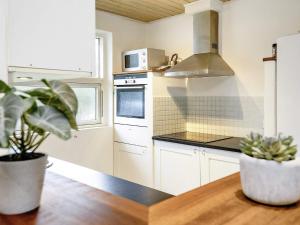 a kitchen with white cabinets and a wooden table at 10 person holiday home in V ggerl se in Marielyst