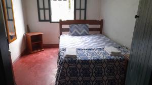 ein kleines Schlafzimmer mit einem Bett und einem Nachttisch in der Unterkunft Casa hospedagem rural em São Roque in Itapevy