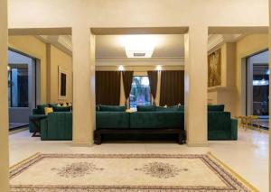 un soggiorno con divani verdi e un tappeto di Palatial Oasis with Pool- VacayX - MARRAKECH a Marrakech
