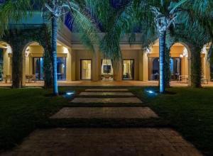 Palatial Oasis with Pool- VacayX - MARRAKECH في مراكش: ساحة فيها نخيل امام مبنى