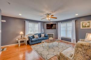sala de estar con sofá azul y ventilador de techo en Patty Posh Palace, en Annapolis