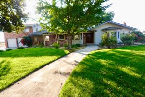 a house with a tree in the middle of a yard at Modern Charm Meets Cozy Elegance in Fowler