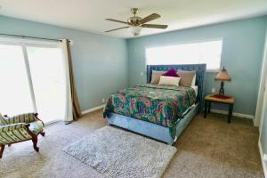 a bedroom with a bed and a ceiling fan at Modern Charm Meets Cozy Elegance in Fowler