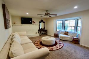 a living room with a white couch and a tv at Modern Charm Meets Cozy Elegance in Fowler