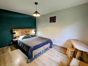 Schlafzimmer mit einem Bett und einem Holztisch in der Unterkunft Gîte Vagney, 3 pièces, 6 personnes - FR-1-589-374 in Vagney