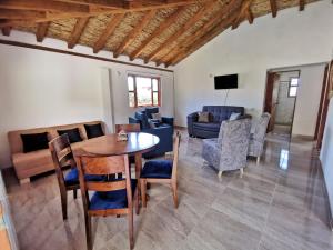 ein Wohnzimmer mit Tisch und Stühlen und einer Couch in der Unterkunft Cabaña San Miguel Arcangel in Villa de Leyva