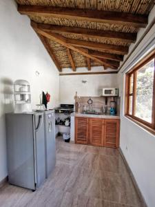 eine Küche mit Holzdecken und einem Kühlschrank in der Unterkunft Cabaña San Miguel Arcangel in Villa de Leyva