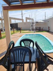 a patio with a table and chairs next to a pool at Espaço gelada in Campo Grande