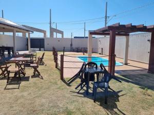 a group of tables and chairs in a patio at Espaço gelada in Campo Grande