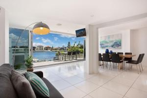 a living room with a couch and a table with chairs at A Perfect Stay - Casa Grande On The Water in Gold Coast