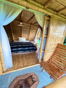 1 dormitorio con 1 cama y un banco en una habitación en Cabanas La Herradura, en Santa Rosa de Cabal