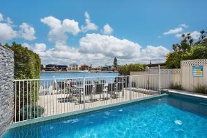 a swimming pool with a fence next to a yard at A Perfect Stay - Casa Grande On The Water in Gold Coast