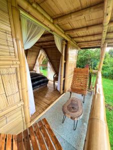 a porch of a cabin with a bench and a bed at Cabanas La Herradura in Santa Rosa de Cabal