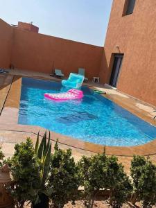 a large swimming pool with two inflatable chairs in it at Villa Anis- VacayX - MARRAKECH in Marrakech