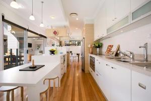 a kitchen with white cabinets and a white counter top at Tobys Beach House in Gold Coast