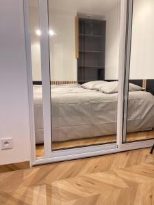 1 dormitorio con puertas correderas de cristal que conducen a una cama en DG Apartment - Le Relais du Lac, proche Disneyland Paris, en Lognes