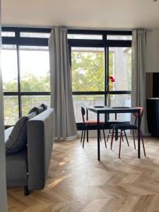 sala de estar con mesa, sillas y sofá en DG Apartment - Le Relais du Lac, proche Disneyland Paris, en Lognes