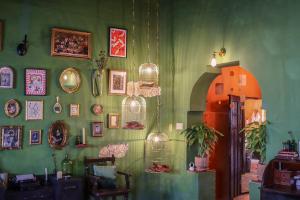 a room with a green wall with lots of pictures at Kuka y Letras in Mérida