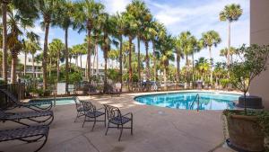 a patio with chairs and a swimming pool with palm trees at Crystal Dunes 405 - 3 BR Beach Front in Destin