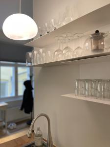 a kitchen with glasses on shelves and a sink at ApartmentInCopenhagen Apartment 1539 in Copenhagen