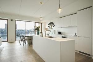 een keuken met witte kasten en een tafel met stoelen bij ApartmentInCopenhagen Apartment 1559 in Kopenhagen