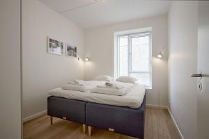 een slaapkamer met een bed met witte lakens en een raam bij ApartmentInCopenhagen Apartment 1559 in Kopenhagen